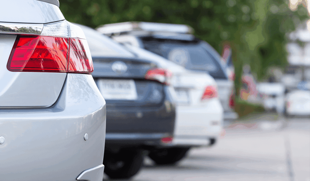 zoom in of rear view of cars in a parking lot